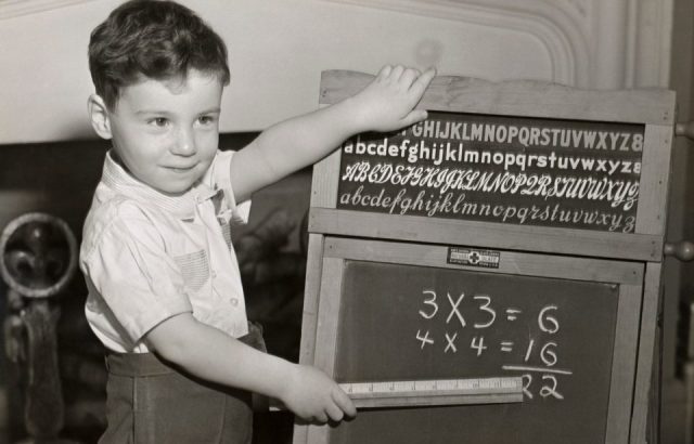 CIRCA 1950s: Boy playing school. 