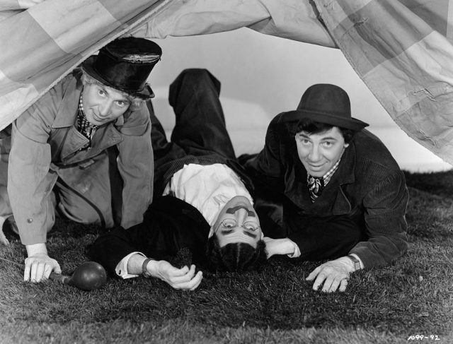 Harpo, groucho, and chico marx peering under a tent in a scene from “marx brothers at the circus. ” undated movie still. (photo credit: bettmann / contributor)