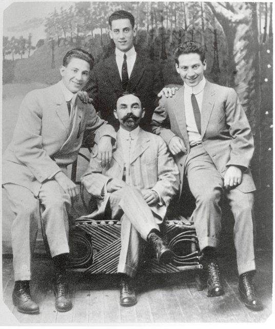 Marx Brothers when they played in vaudeville under the name of The Three Nightingales. Left to right, Gummo; Julius Schickler, their uncle who served as manager; and Harpo. Standing is Groucho. (Photo Credit: Bettmann / Contributor)