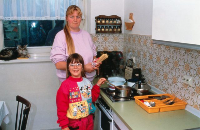 Woman and her daughter making food in a kitchen