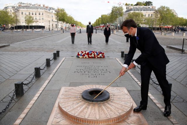 French president emmanuel macron lights up the flame at the tomb of the unknown soldier during a ceremony marking the 76th anniversary of victory in europe (ve-day), marking the end of world war ii in europe, in paris on may 8, 2021. (photo credit: christian hartmann/pool/afp via getty images)