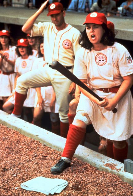 Rosie O'Donnell holding a baseball bat in her hands, while Tom Hank looks on