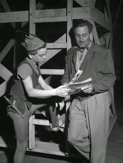 Bobby Driscoll dressed as Peter Pan and Walt Disney reading a script