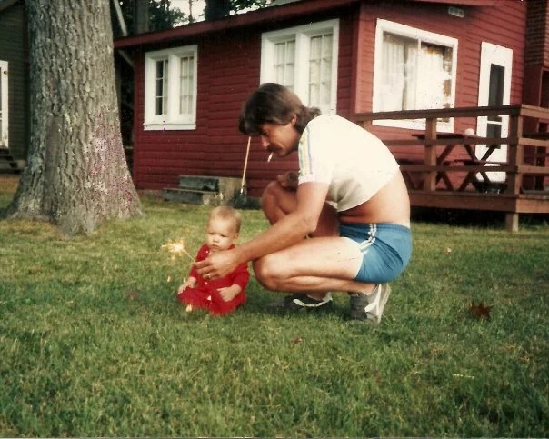 dad showing his baby a sparkler 