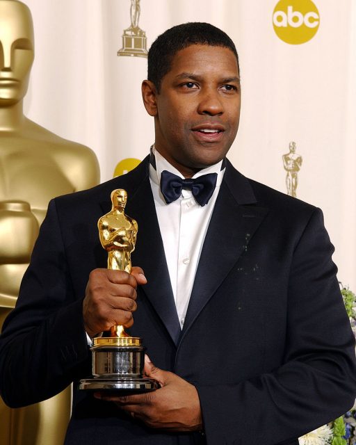 Denzel Washington holding up his Oscar