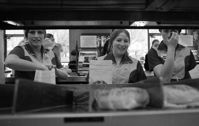 Three female mcdonald's employees bagging hamburgers