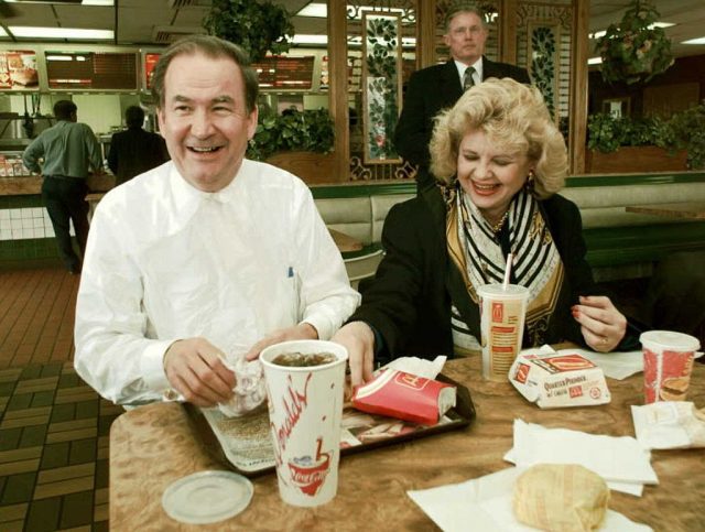 Pat buchanan and his wife, shelley, eating at a table at mcdonald's
