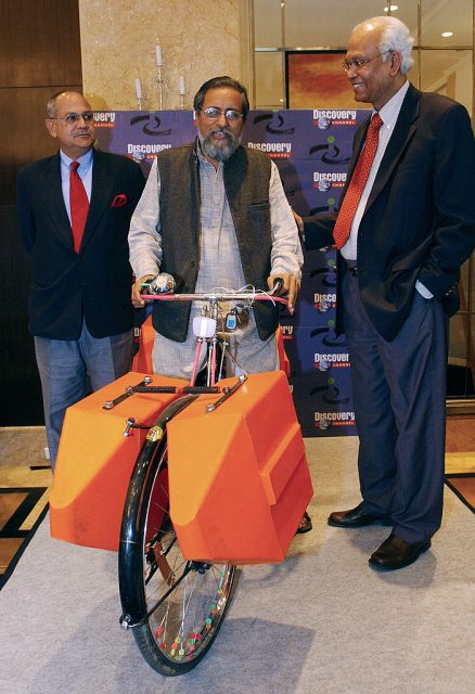 Deepak Shourie, Anil Gupta, and R. A. Mashelkar pose with an amphibious bicycle, a conventional cycle retrofitted to cross water bodies (Photo Credit: MANPREET ROMANA/AFP via Getty Images)