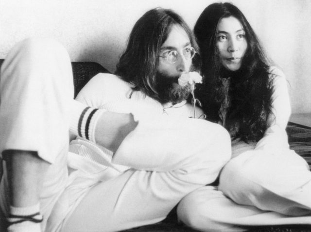 John Lennon leaning against Yoko Ono