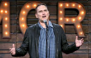Norm Macdonald standing behind a microphone