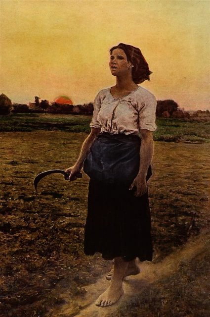 Woman walking through a field at sunrise