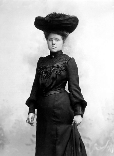 Victorian woman wearing a black dress and hat