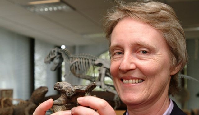 Dr. Angela Milner holding a fossil