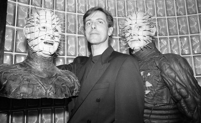 The Pinhead character from Clive Barker’s “Hellraiser” films presents a bust of himself with Horror creator Clive Barker to Planet Hollywood in 1992 in New York City, New York. (Photo Credit: Catherine McGann/Getty Images)