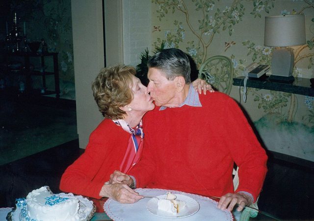 Former President Ronald Reagan gets a kiss from his wife Nancy on the occasion of his 89th birthday February 6, 2000, at their home in Bel Air, California. (Photo Credit: Ronald Reagan Presidential Foundation/Getty Images)