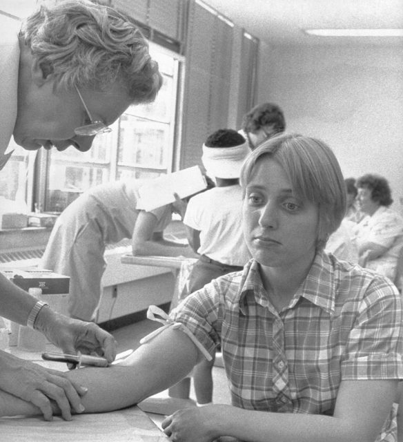 Niagara Falls, New York- A Red Cross nurse takes a blood sample from Maureen Paonessa, 23, at a clinic set up in the 99th Street Elementary School. State Health officials are performing the tests to determine the effects of chemical contamination. Almost 100 families live in the area but officials say 37 families are the most directly affected. (Photo Credit: Bettmann / Contributor)