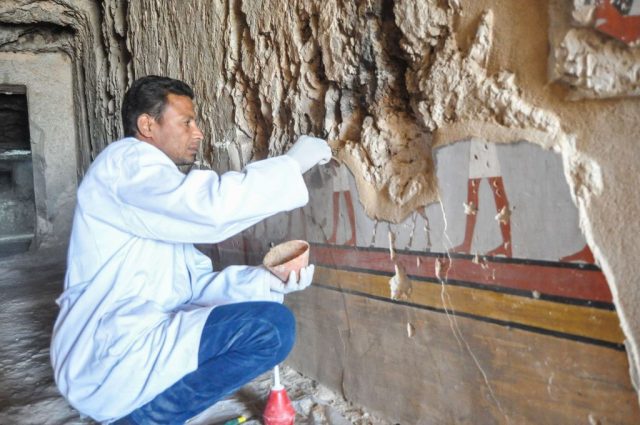 Archaeologist examining hieroglyphics on the wall