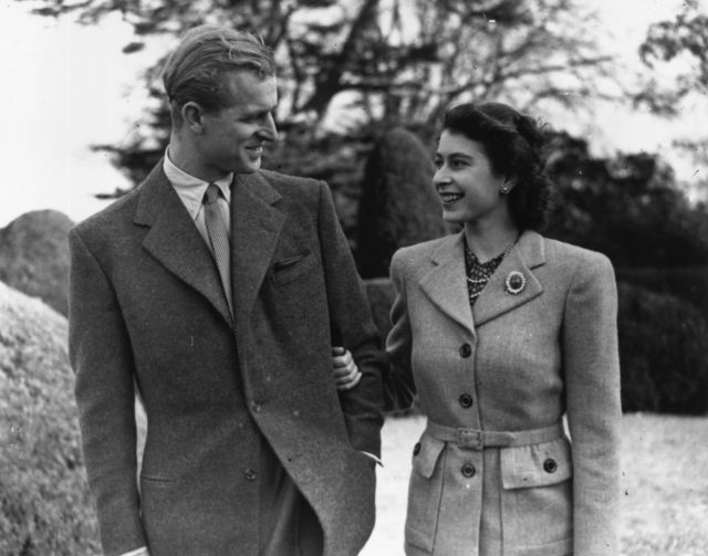 Prince Philip and Queen Elizabeth gazing at each other during a stroll through a park