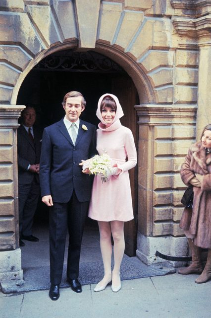 Andrea Dotti and Audrey Hepburn standing below an arched doorway at a church