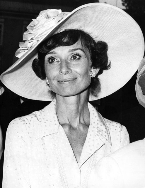 Audrey Hepburn wearing a white suit and a large white hat