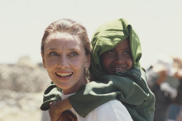 Audrey Hepburn giving a piggy back ride to an Ethiopian child
