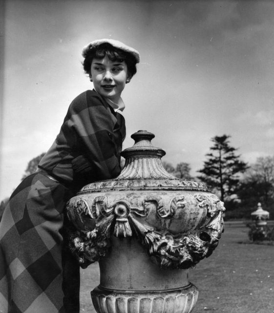 Audrey Hepburn leaning against a garden bird feeder