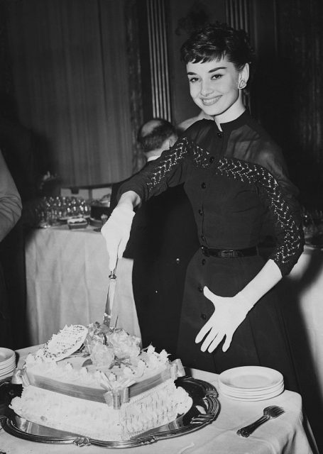 Audrey Hepburn cutting a cake
