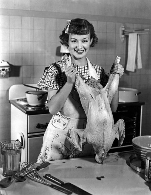 Anne Shirley holding a turkey by its legs