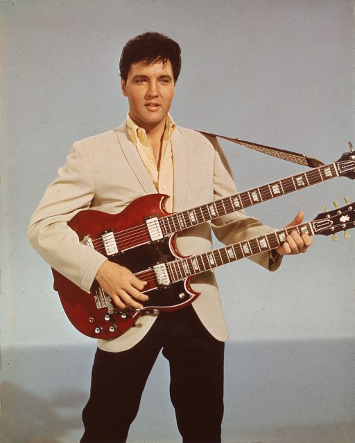 Portrait of American singer and actor Elvis Presley holding a 1965 Gibson EBS-1250 Double Bass (a combined 6-string and bass guitar), circa 1966. Elvis is seen playing the guitar in his 1966 film, ‘Spinout’. (Photo Credit: Hulton Archive/Getty Images)