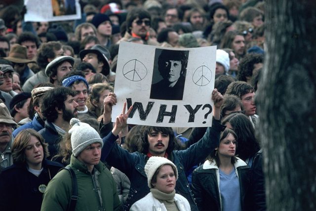 Fan holding up a sign for John Lennon following his murder