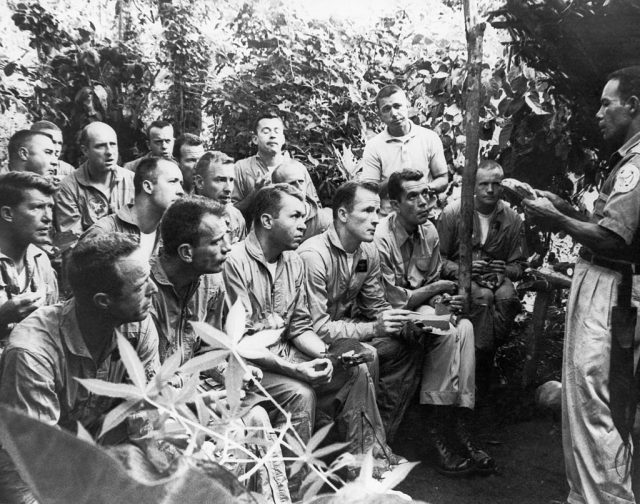 NASA astronauts sitting before a lecturer in the jungle