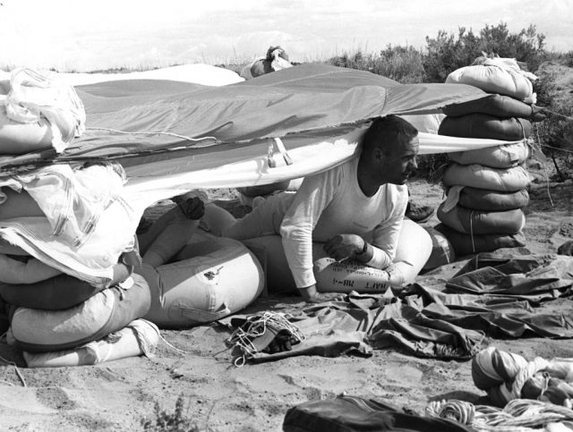 Neil Armstrong sitting beneath a makeshift tent in the desert