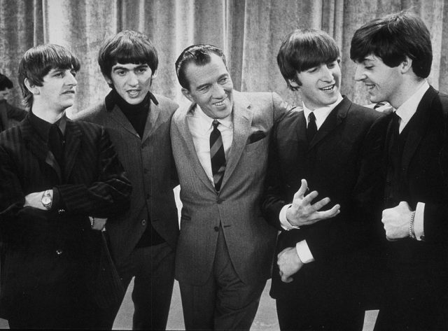 The Beatles standing with Ed Sullivan