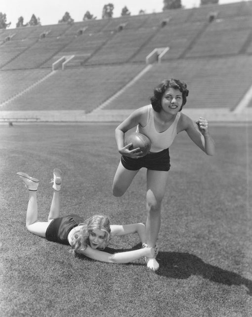 Lillian Roth and Virginia Bruce running on a football pitch
