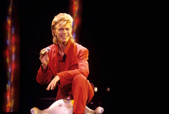 David Bowie wearing an orange suit on stage
