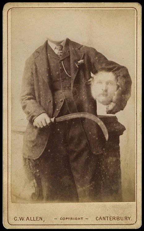 Man sitting with his head under his arm and a weapon in the other