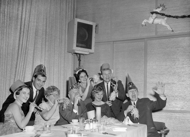 Group of people dressed in fancy clothes and wearing party hats