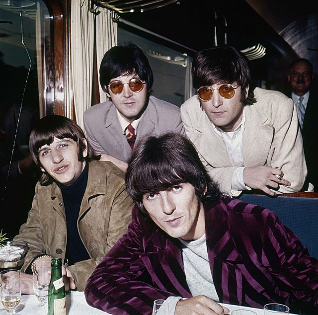 The Beatles sitting together at a restaurant booth