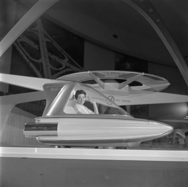 Woman sitting within a model of the Ford Levacar