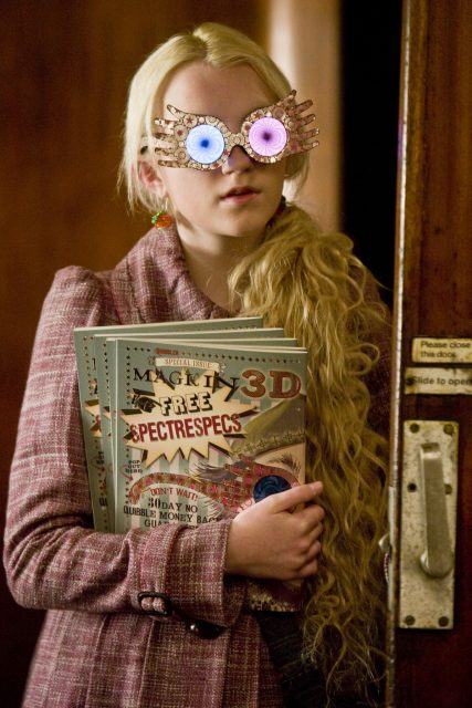 Luna Lovegood wearing Spectrespecs and holding editions of The Quibbler