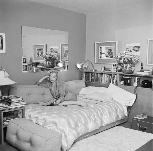 Marilyn Monroe reading on a sofa bed 