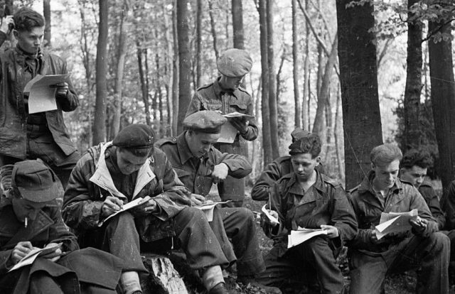 British POWs writing letters in the forest