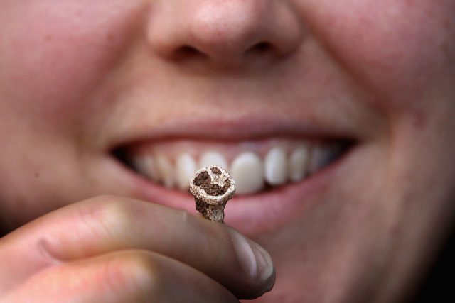 a person holding up a Viking tooth