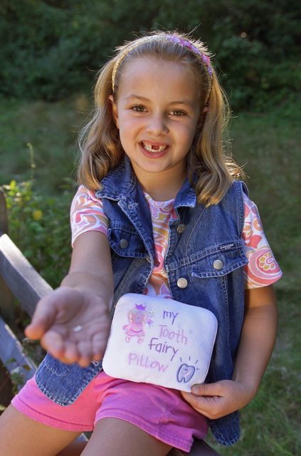a child with her special Tooth Fairy pillow