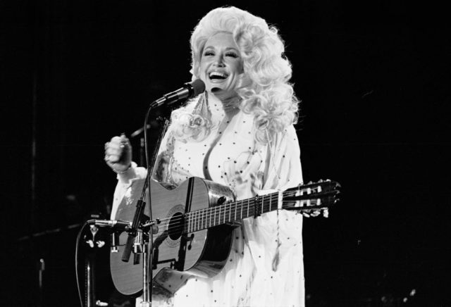 Dolly Parton performing with a guitar 