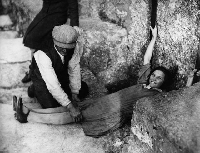 1930: A girl lies flat on the ground, in order to kiss the Blarney Stone in Blarney Castle, Cork city. (Photo Credit: General Photographic Agency/Getty Images)