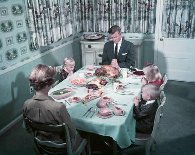 Family saying Grace over Thanksgiving dinner