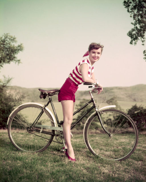 Debbie Reynolds poses on a modern women's bicycle