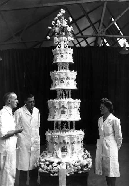 Attendants stand near a 9-foot tall cake