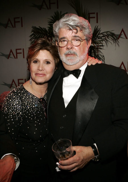 Carrie Fisher and George Lucas embrace at a party